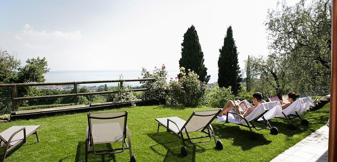 Colle San Giorgio grasveld met ligbedden bij zwembad met uizicht op Garda meer