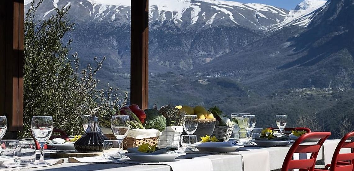 Aristi Mountain Resort terrass met besneeuwde bergtoppen