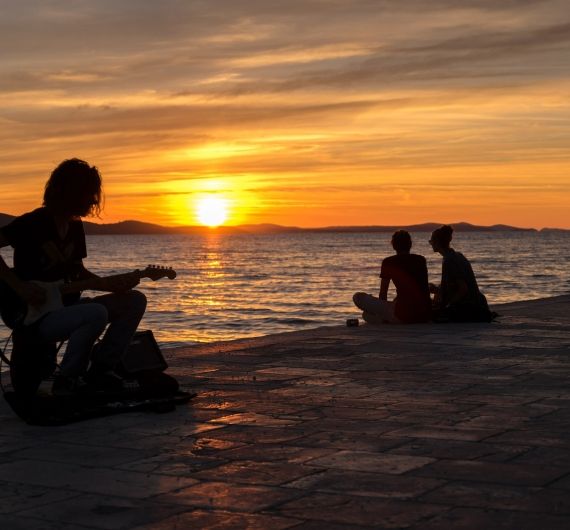 Bij de boardwalk van Zadar bij zonsondergang