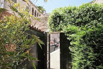 Oltre Il Giordino doorkijkje vanuit tuin en poort naar de kanalen van Venetie